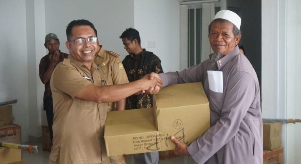 Sekdin Diskominfo Kabupaten Buton, Alimudin Matu, S.Pd.,M.Si (kiri) Secara Simbolis Menyerahkan Bantuan Akses Internet Pada Kepala Sekolah di Pasarwajo, Senin (23/12/2024) 
