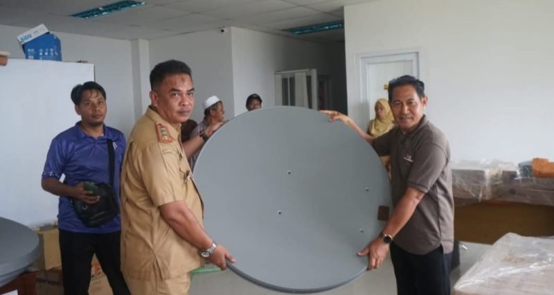 Kepala Dinas Komunikasi Informatika dan Persandian (Diskominfo) Kabupaten Buton, H. Suhardin Sanusi, ST., M.Si, (kiri) Menyerahkan Perangkat Akses Internet BAKTI Kepada Kepala Sekolah di Pasarwajo, Senin (23/12/2024)