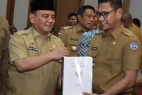 Pj. Gubernur Sulawesi Tenggara, Andap Budi Revianto menyerahkan Naskah Akademik dan  draf Ranperda tentang Sistem Penyelenggaraan Pemerintahan Daerah Berbasis Data Desa dan Kelurahan Presisi, Senin (20/1/2025). 
